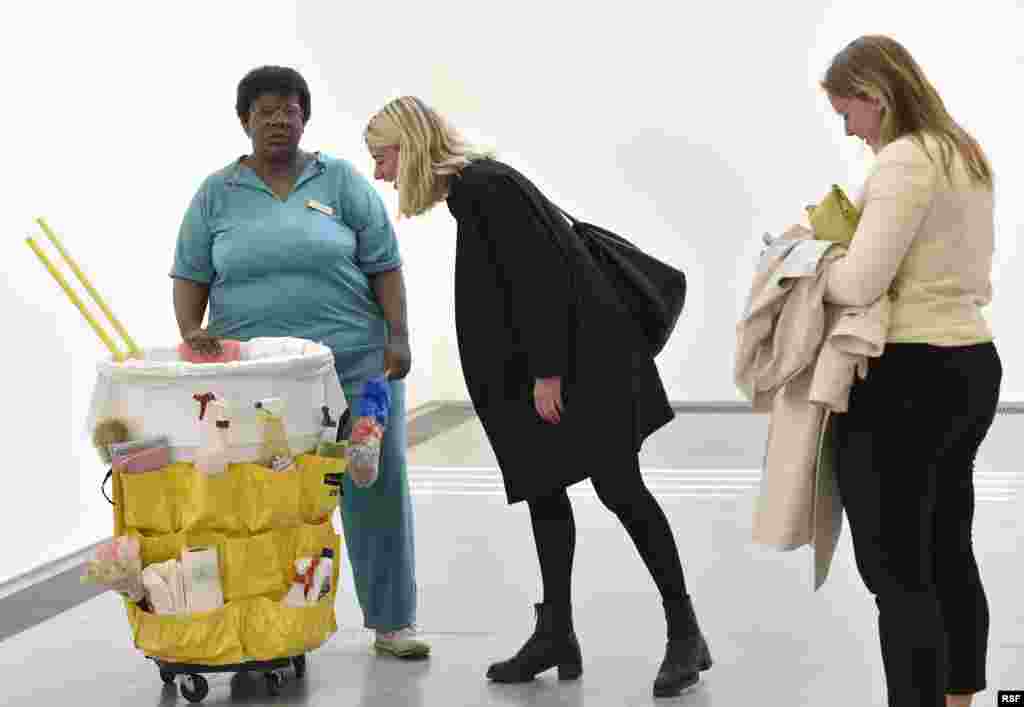 Visitors view a sculpture entitled &#39;Queenie II&#39; by the late U.S. artist Duane Hanson, on display at the Serpentine Sackler Gallery in London. Hanson&#39;s lifelike sculptures portraying working-class Americans are being brought together in the largest show of his work in Britain since 1997.