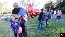 Des familles se retrouvent après la fusillade du lycée Marjory Stoneman Douglas à Parkland en Floride le 14 février 2018. 