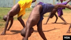 Several young orphans practice the capoeira moves needed to participate in a “roda” — a “round” where the participants dance and perform martial arts moves to music, April 20, 2017. (Z. Baddorf/VOA)