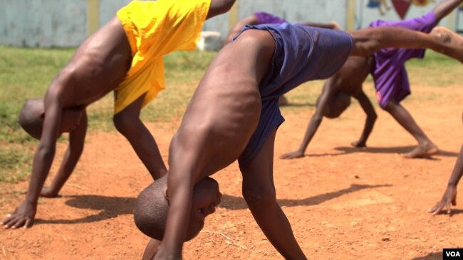Several young orphans practice the capoeira moves needed to participate in a “roda” — a “round” where the participants dance and perform martial arts moves to music, April 20, 2017. (Z. Baddorf/VOA)