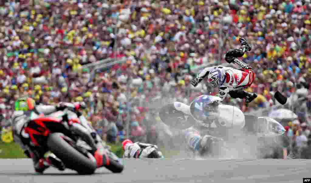 Pebalap Jepang Hiroshi Aoyama (kanan) dari Tim Repsol Honda jatuh dari motornya dalam MotoGP Grand Prix, Jerman di Sachsenring Circuit di Hohenstein-Ernstthal, Jerman timur.