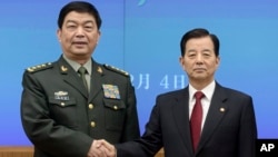 Chinese Defense Minister Chang Wanquan, left, poses with his South Korean counterpart, Han Min-goo, for photographers prior to a meeting at the Defense Ministry in Seoul, Feb. 4, 2015.