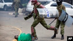 FILE -May 16, 2016, Afisa wa kikosi cha kuzuia ghasia akirejea kumpiga mateke mwandamanaji aliyeanguka chini wakati akijaribu kuwakimbia wakati wa maandamano mjini Nairobi, Kenya. Tukio hilo lililaaniwa na Wakenya na wanaharakati wa haki za binadamu kutoka Kenya na Marekani