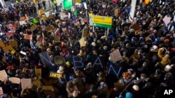 Demonstran berkumpul di bandara internasional John F. Kennedy International di New York, 28 Januari 2017, setelah dua pengungsi Irak ditahan ketika berusaha memasuki Amerika.