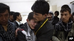 A Pakistani man comforts another mourning for a family member who died in a bomb blast, at local hospital in Quetta, Pakistan on Feb. 16, 2013.