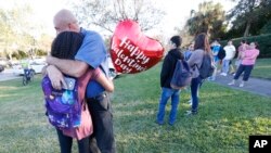 Des familles se retrouvent après la fusillade du lycée Marjory Stoneman Douglas à Parkland en Floride le 14 février 2018. 