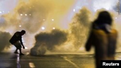 Un grupo de manifestantes protesta la noche del domingo contra un toque de queda impuesto en Ferguson, Missouri.