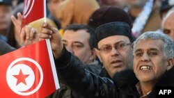 Les Tunisiens font flotter des drapeaux sur l'avenue de Habib Bourguiba, le 14 janvier 2018. 