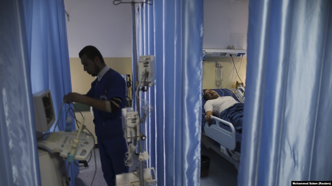Seorang teknisi menyiapkan peralatan saat pasien berbaring di tempat tidur di ruang operasi Rumah Sakit Indonesia di Jalur Gaza utara, 4 Januari 2016. (Foto: REUTERS/Mohammed Salem)