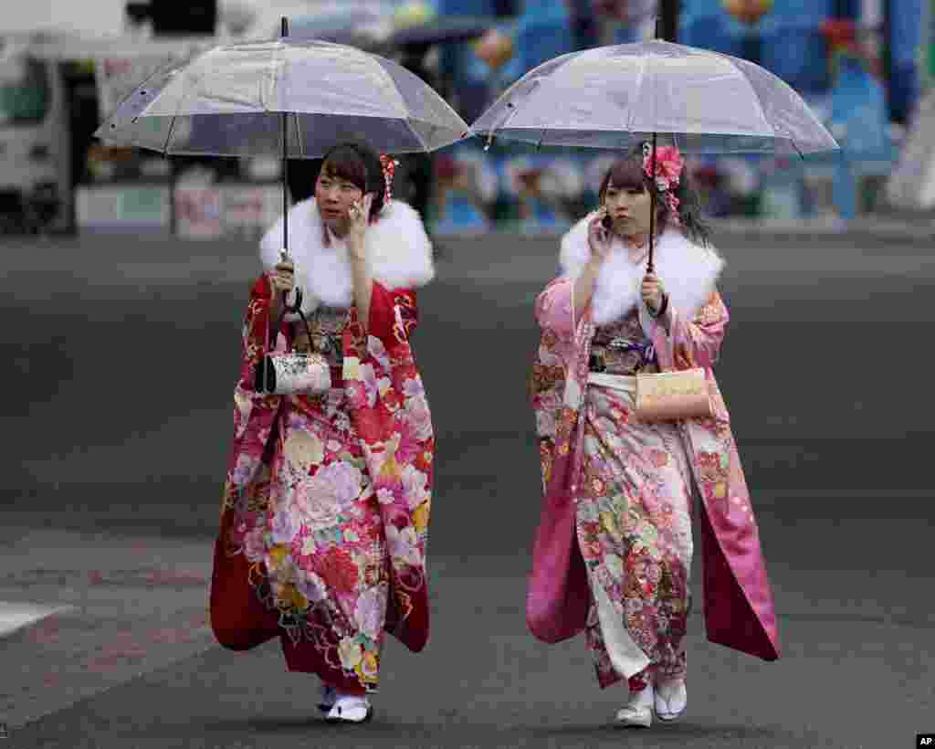 Japanese participants clad in kimono walk together after a Coming of Age ceremony at Toshimaen amusement park on the national holiday in Tokyo.