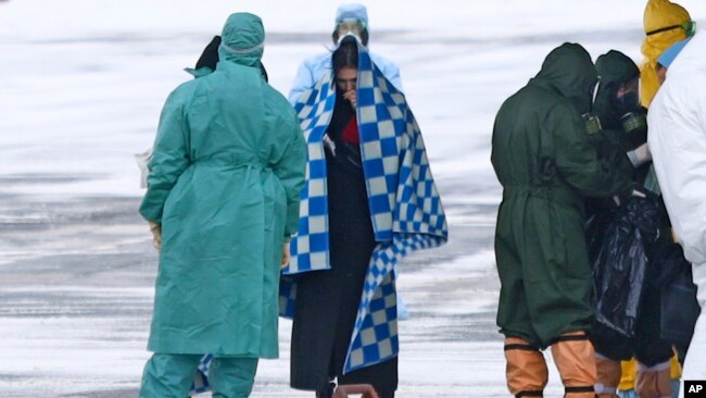 身穿防护服的俄罗斯医护人员在秋明附近的一个机场迎接俄罗斯军机从武汉撤回的侨民。（2020年2月5日）
