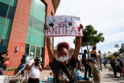 FILE - A woman holds up a sign addressing Antifa at a George Floyd protest in Los Angeles, California, June 1, 2020.