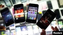FILE - Fake iPhones are displayed at a mobile phone stall in Shanghai, China. 