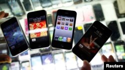 FILE - Fake iPhones are displayed at a mobile phone stall in Shanghai, China, Aug.11, 2011.