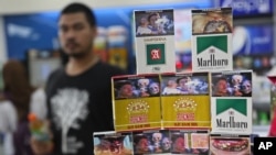 Bungkus-bungkus rokok yang memasang gambar peringatan, dipajang di sebuah toko di Jakarta (24/6). (AP/Tatan Syuflana)