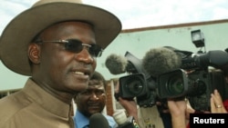 FILE - Former Minister of Information Jonathan Moyo talks to reporters before voting in Tsholotsho, Zimbabwe. Moyo, who was fired from parliament in November, recently said the international community must help remove the military government that has taken power in Zimbabwe.