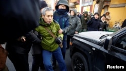 中國警察把一名正在天津法庭外支持維權律師王全璋的支持者抓走塞入警車。（2018年12月26日）