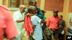 In this image taken from video, people assist victims after two explosions hit a rally of M23 rebel group leaders and residents in Bukavu, Democratic Republic of Congo, on Feb. 27, 2025.