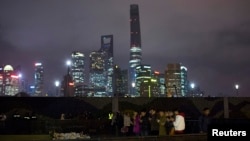 People offer prayers during a memorial ceremony for people who were killed in a stampede incident during the new year celebrations on the Bund, in Shanghai January 6, 2015.