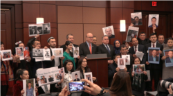 在参加报告发布会上，观众席中有大约一半的人是维吾尔人，他们许多人举着自己失踪亲友的照片。