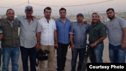 Slain Iraqi journalist Yasser Faysal al-Joumaili (holding a camera) pictured with Al Jazeera journalist Imran Khan (right) in Domiz refugee camp in Northern Iraq in September 2013. (Imran Khan/Al Jazeera English)