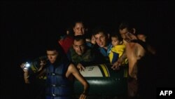 Un grupo de migrantes son arrastrados a través del Río Grande por traficantes de personas mientras cruzan la frontera entre Estados Unidos y México en balsas en Roma, Texas, el 8 de julio de 2021.
