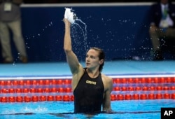 Hungary's Katinka Hosszu celebrates after setting a new world record and winning the gold medal in the women's 400-meter individual medley final during the swimming competitions at the 2016 Summer Olympics, Aug. 6, 2016.