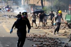 Protesters run as police fire tear gas near Hong Kong Polytechnic University in Hong Kong, Monday, Nov. 18, 2019.