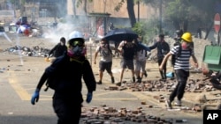 FILE - Protesters run as police fire tear gas near Hong Kong Polytechnic University in Hong Kong, Nov. 18, 2019. 