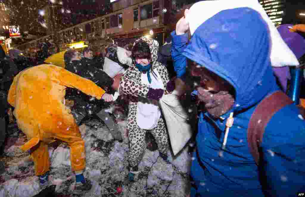 Participants of a flashmob throw pillows and feathers on the Reeperbahn in Hamburg, Germany. A few hundred people took part in the pillow fight to protest against the &quot;danger zone&quot; set up by the police. 