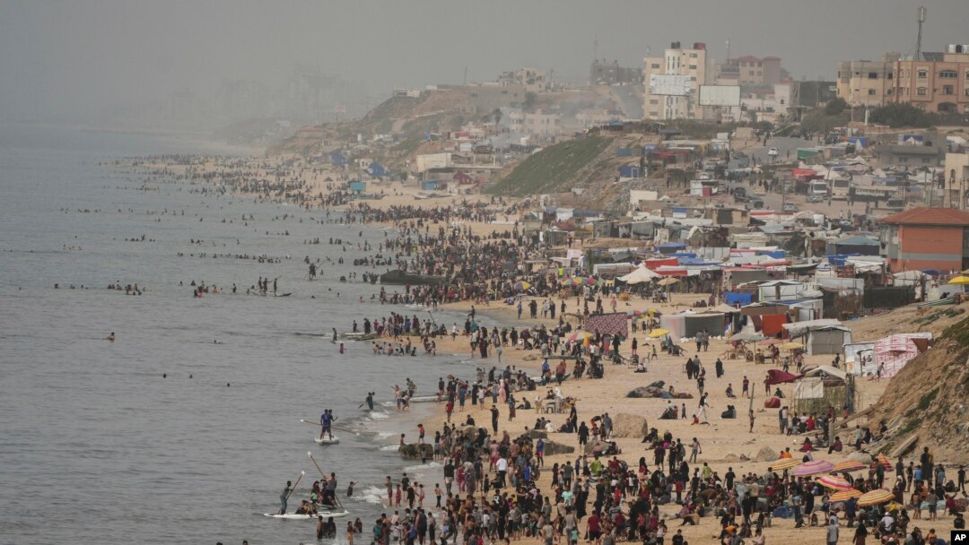 Palestinos desplazados tratan de refrescarse en el mar Mediterráneo, en plena ola de calor en Deir al Balah, en la Franja de Gaza, el 25 de abril de 2024