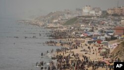 Palestinos desplazados tratan de refrescarse en el mar Mediterráneo, en plena ola de calor en Deir al Balah, en la Franja de Gaza, el 25 de abril de 2024