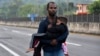 Un migrante carga a un niño por Tapachula, estado de Chiapas, México, el jueves 2 de enero de 2025, como parte de una caravana de migrantes que intentan llegar a la frontera con Estados Unidos. (AP Foto/Edgar H. Clemente).