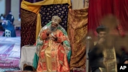 FILE - In this April 17, 2020, photo, Abune Mathias, the 6th Patriarch of the Ethiopian Orthodox Church, uses hand sanitizer during an Orthodox Good Friday service at Holy Trinity Cathedral in Addis Ababa, Ethiopia. 