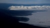 FILE - Pegunungan yang diselimuti salju dan Samudra Arktik di pantai Svalbard dekat Longyearbyen, Norwegia, 5 April 2023.