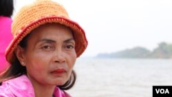 Phloak Sareth, 49, a villager from Kratie province's Sambor district, sits on a motorized boat along the Mekong River, March 11, 2020. (Sun Narin/VOA Khmer)