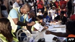 FILE - An electoral worker sorts ballots during the counting of votes for Guinea-Bissau's presidential runoff in Bissau, Dec. 29, 2019.