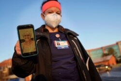 Nurse Jessica Franz shows a photo of her mother-in-law, Elaine Franz, outside Olathe Medical Center after working the graveyard shift November 26, 2020, in Olathe, Kansas. Elaine Franz died November 10 after contracting COVID-19.