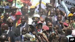 Rais wa Zimbabwe Robert Mugabe,akisalimiana na wananchi wanaomuunga mkono katika eneo la Mutare, Zimbabwe.