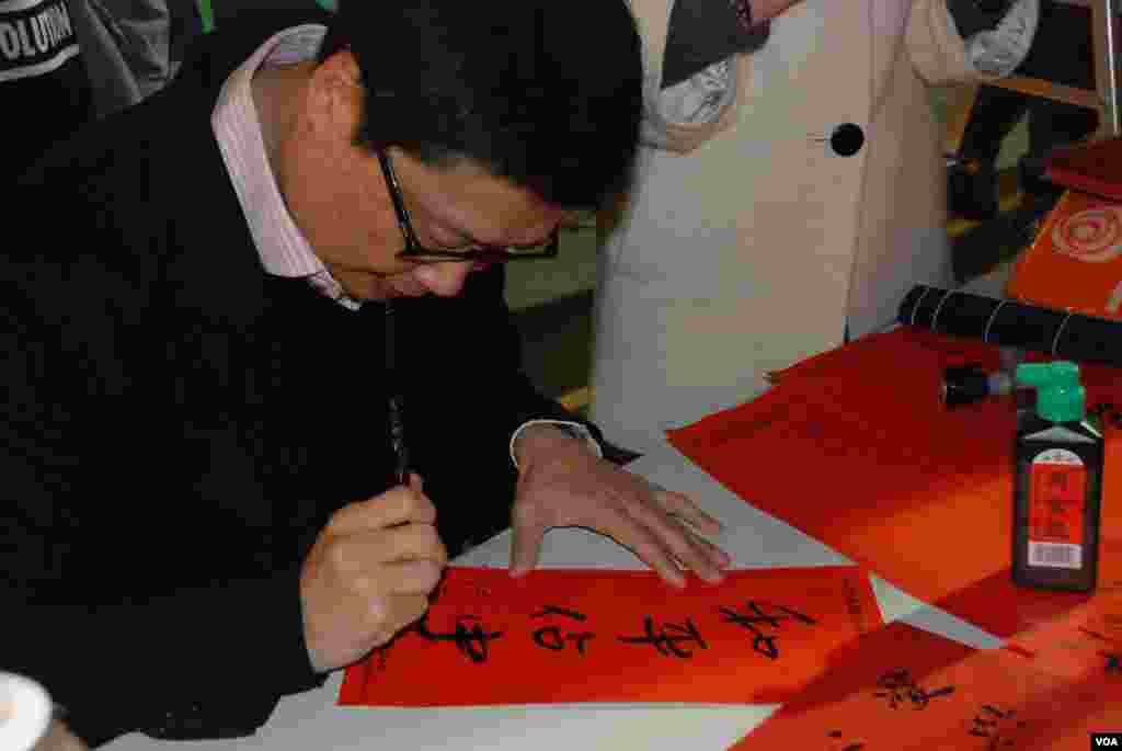 Chan Kin Man, co-organizer of the Occupy Central movement, writes calligraphy at the pan-democracy parties&rsquo; vending stall.