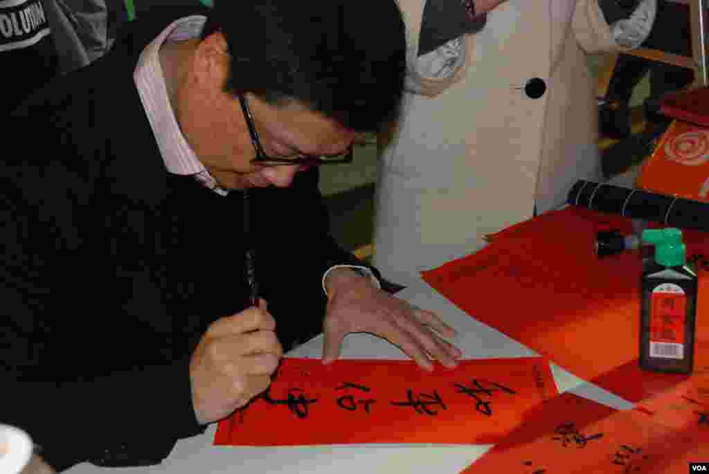 Chan Kin Man, co-organizer of the Occupy Central movement, writes calligraphy at the pan-democracy parties’ vending stall.