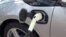 In this image taken from video, an electric vehicle is plugged into a charger, March 2017.