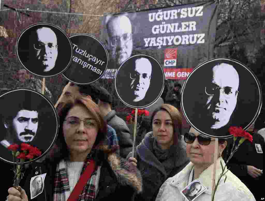 Women hold posters of Ugur Mumcu, Turkey&#39;s best-known investigative journalist, who was killed in 1993, and one of Ali Ismail Korkmaz, a Turkish student killed during last summer&#39;s protests, as thousands of people gathered to commemorate the anniversary of Mumcu&#39;s death in Ankara. Banner in the background reads: &quot; We are living days without Ugur (which also means luck).&quot;