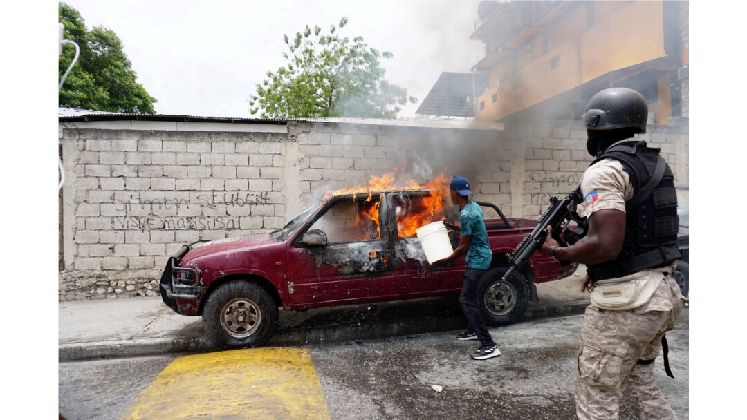 A worker tries to extinguish a burning vehicle that belongs to Radio Tele-Ginen during a protest demanding the resignation of President Jovenel Moise in Port-au-Prince, Haiti, June 10, 2019.