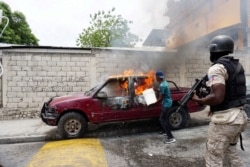 A worker tries to extinguish a burning vehicle that belongs to Radio Tele-Ginen during a protest demanding the resignation of President Jovenel Moise in Port-au-Prince, Haiti, June 10, 2019.