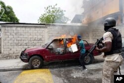 A worker tries to extinguish a burning vehicle that belongs to Radio Tele-Ginen during a protest demanding the resignation of President Jovenel Moise in Port-au-Prince, Haiti, June 10, 2019.