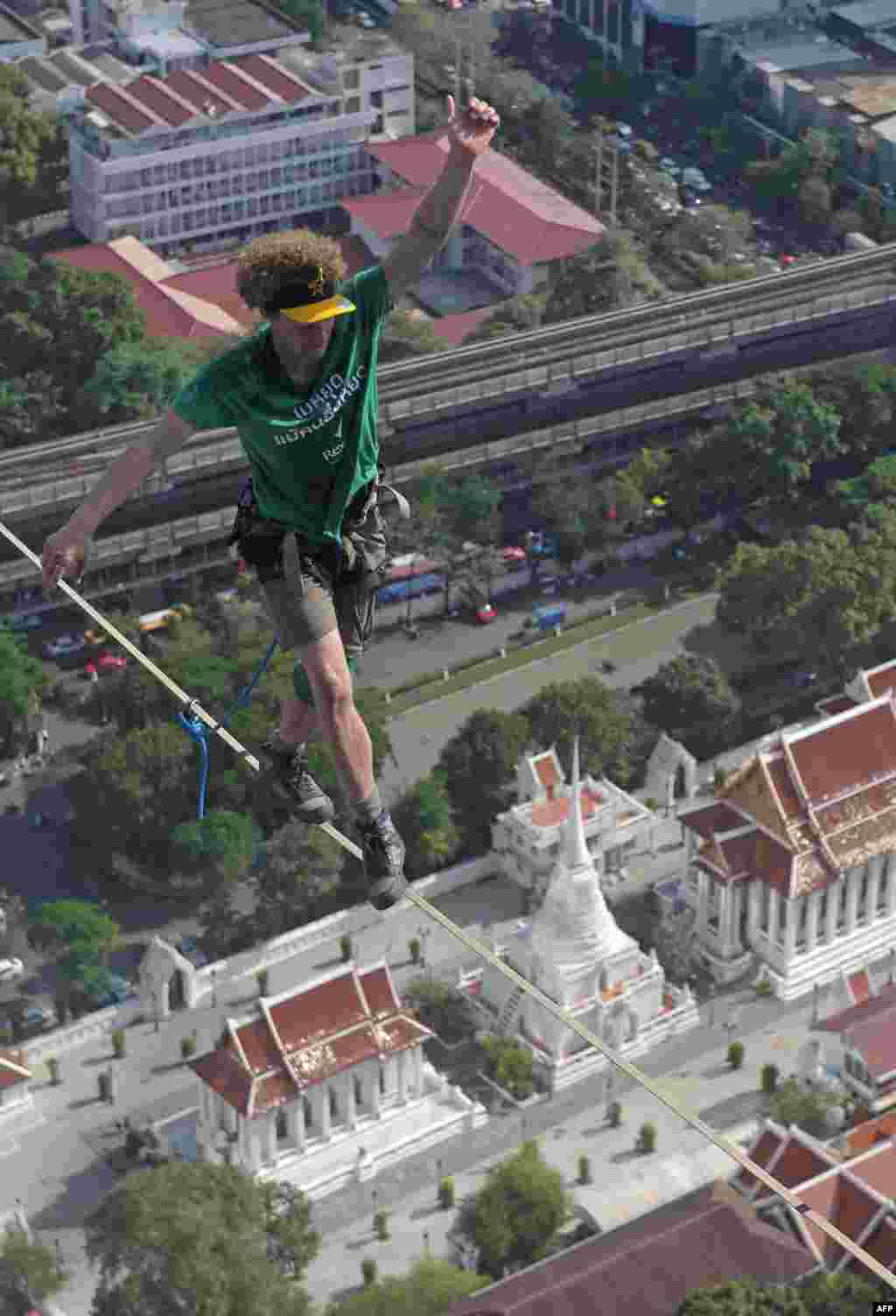 U.S. slackliner, Andy Lewis, balances as he walks on a highline between buildings in Bangkok, Thailand.