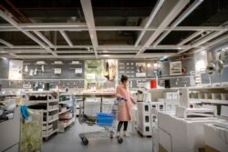 A woman wears a face mask to protect against coronavirus infection as she shops at an IKEA store in Beijing, March 21, 2020.