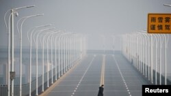 A man who arrived from Hubei province crosses the Jiujiang Yangtze River Bridge near a checkpoint in Jiujiang, Jiangxi province, China, as the country is hit by an outbreak of a new coronavirus, Jan. 31, 2020.