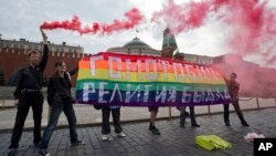 Gay rights activists hold a banner reading 'Homophobia - the religion of bullies' during their action in protest at homophobia, on Red Square in Moscow, Russia, July 14, 2013.
